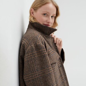 Brown, dark brown and beige checkered fall winter warm shirt jacket with warm lining, long sleeves and pockets.