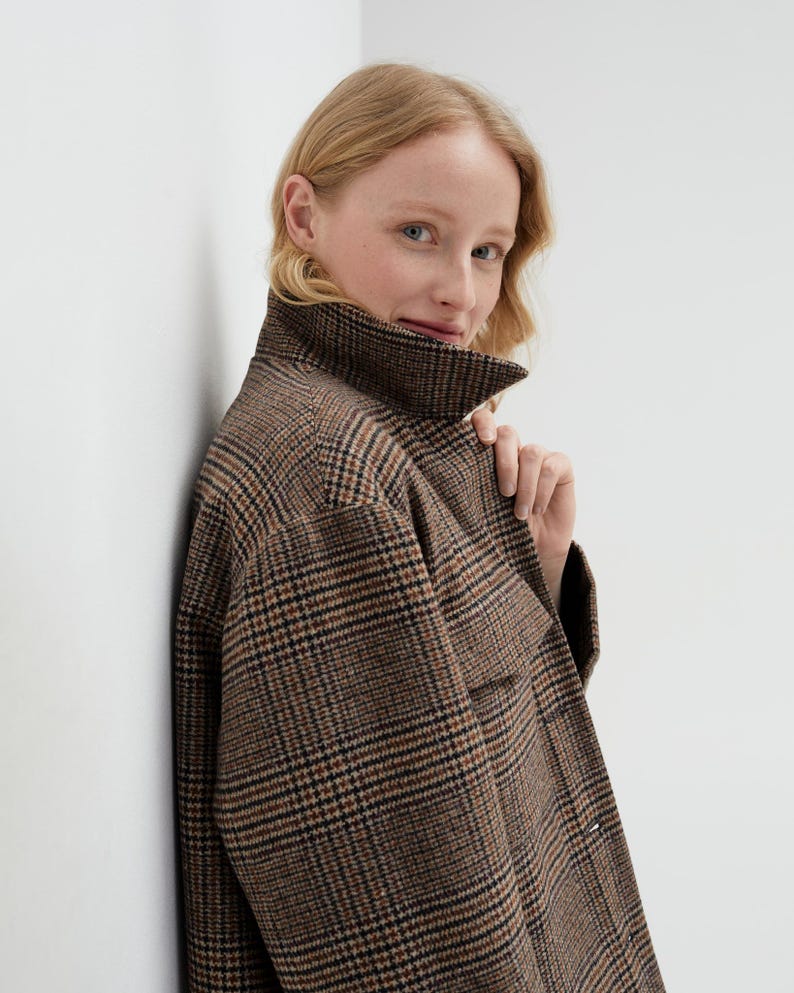 Brown, dark brown and beige checkered fall winter warm shirt jacket with warm lining, long sleeves and pockets.
