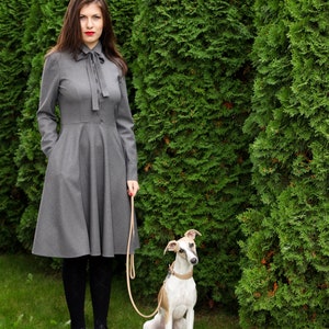Elegant wool button up shirt dress with long sleeves. This midi dress is fitted at the top and has a flare skirt with side seam pockets.