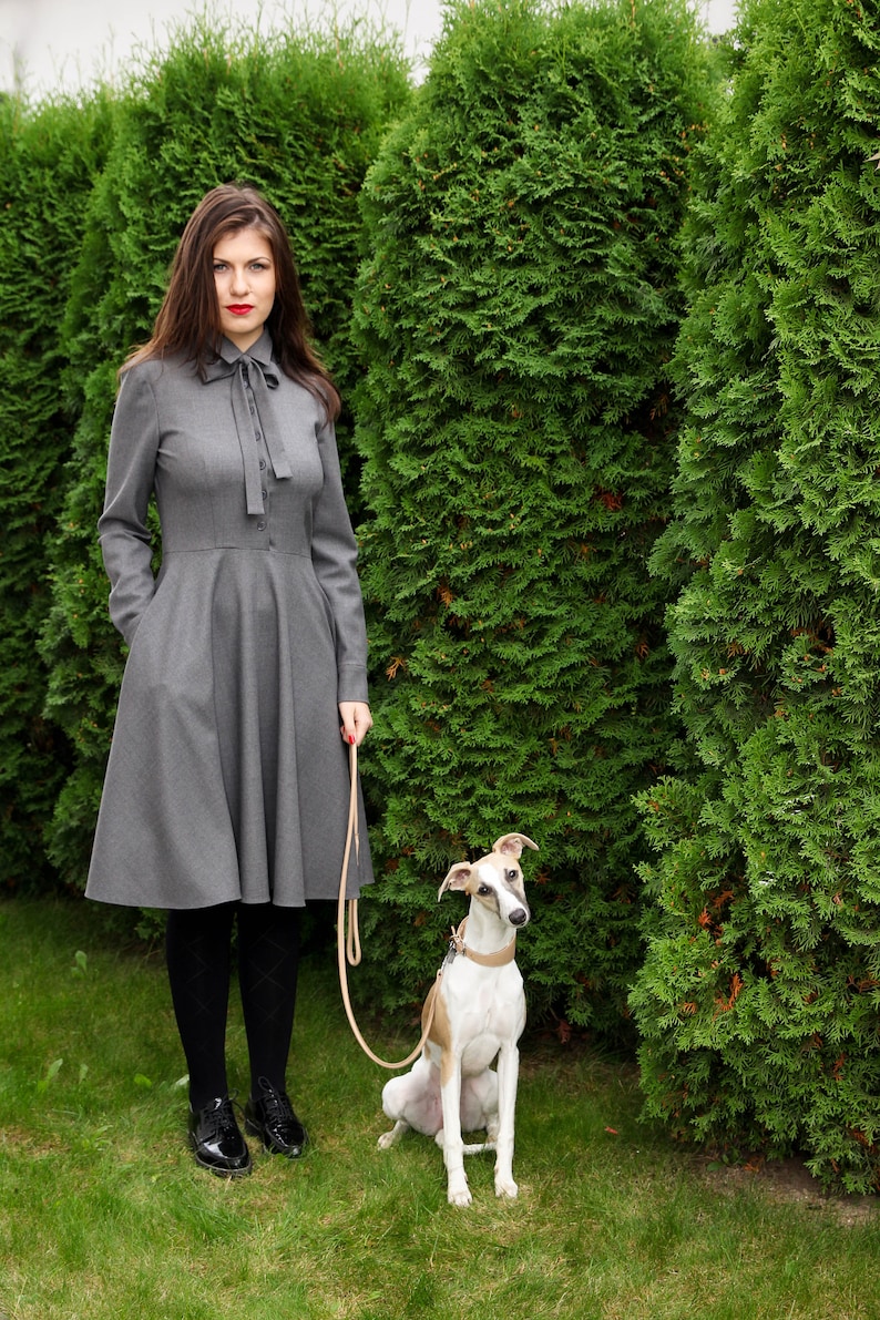Elegant wool button up shirt dress with long sleeves. This midi dress is fitted at the top and has a flare skirt with side seam pockets.