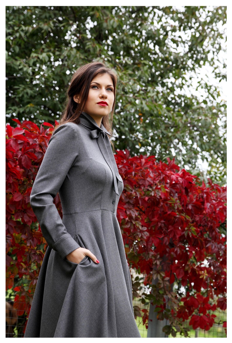 Elegant wool button up shirt dress with long sleeves. This midi dress is fitted at the top and has a flare skirt with side seam pockets.