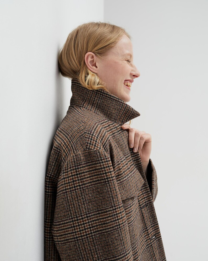 Brown, dark brown and beige checkered fall winter warm shirt jacket with warm lining, long sleeves and pockets.