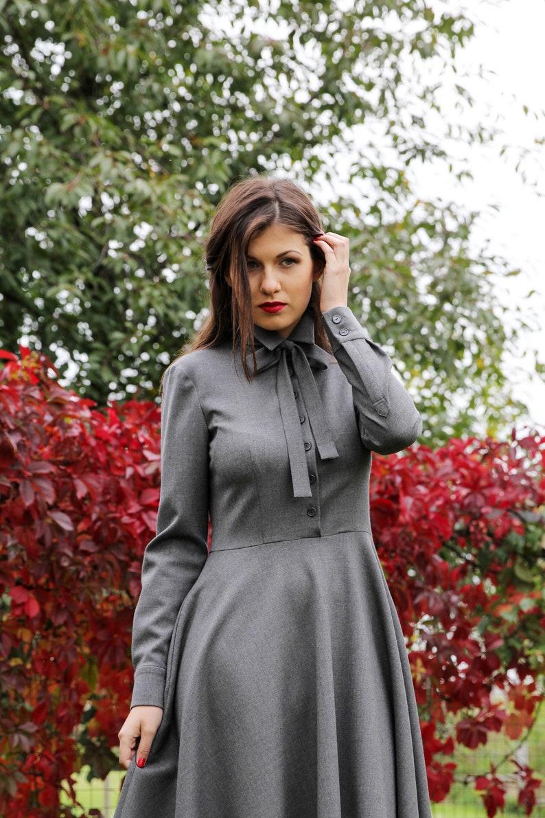 Elegant wool button up shirt dress with long sleeves. This midi dress is fitted at the top and has a flare skirt with side seam pockets.