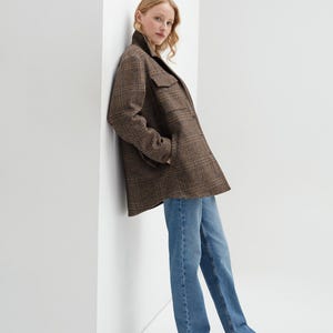 Brown, dark brown and beige checkered fall winter warm shirt jacket with warm lining, long sleeves and pockets.