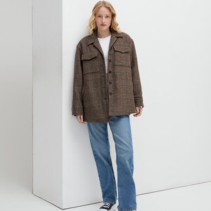 Brown, dark brown and beige checkered fall winter warm shirt jacket with warm lining, long sleeves and pockets.
