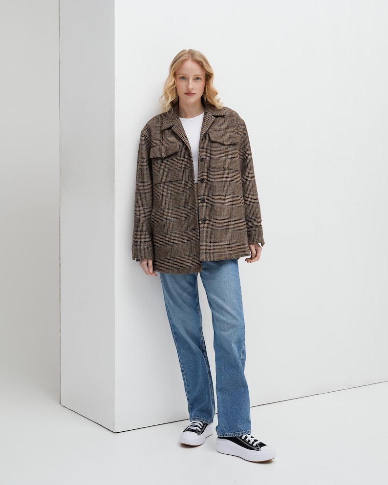 Brown, dark brown and beige checkered fall winter warm shirt jacket with warm lining, long sleeves and pockets.