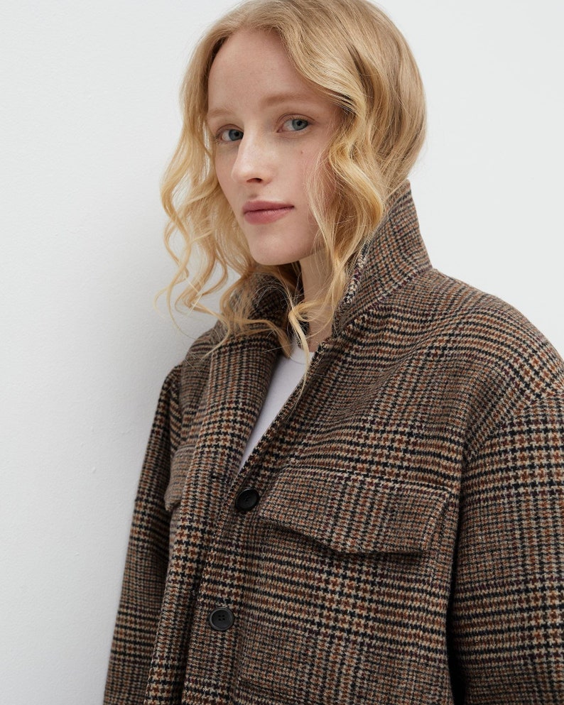 Brown, dark brown and beige checkered fall winter warm shirt jacket with warm lining, long sleeves and pockets.