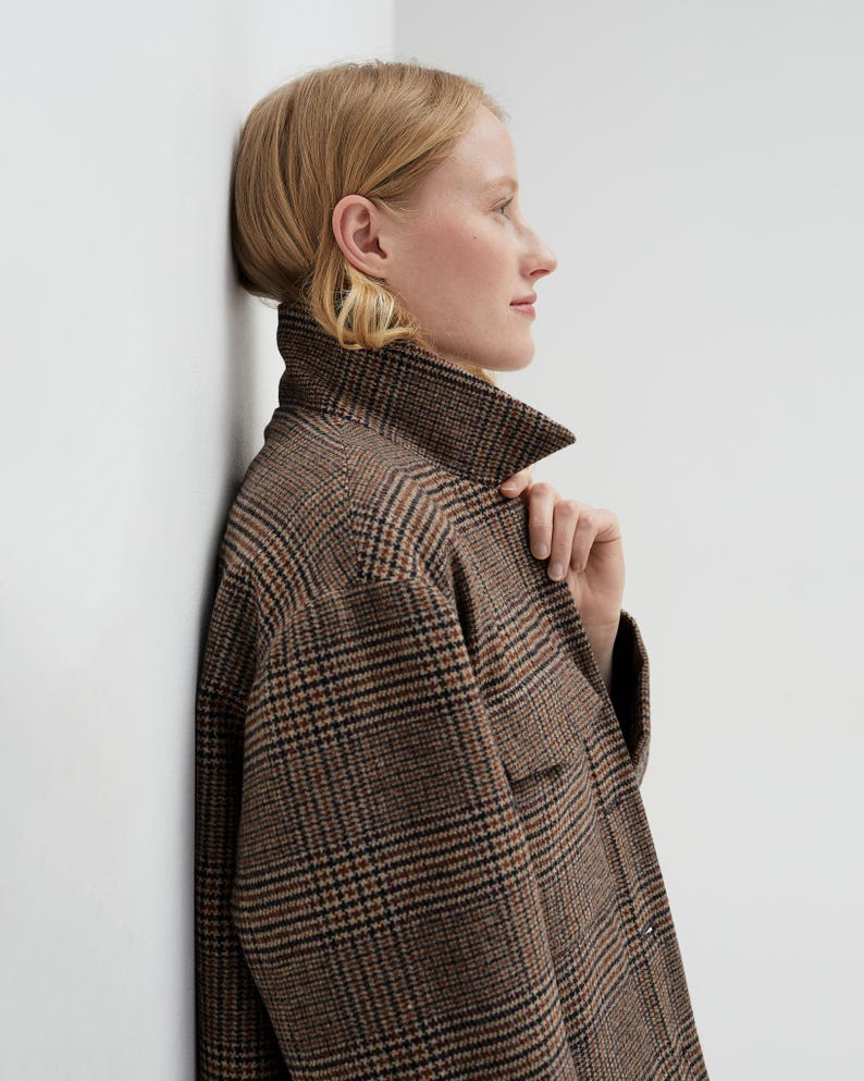 Brown, dark brown and beige checkered fall winter warm shirt jacket with warm lining, long sleeves and pockets.