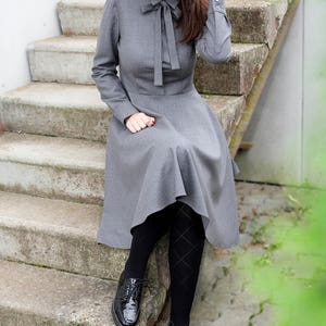 Elegant wool button up shirt dress with long sleeves. This midi dress is fitted at the top and has a flare skirt with side seam pockets.