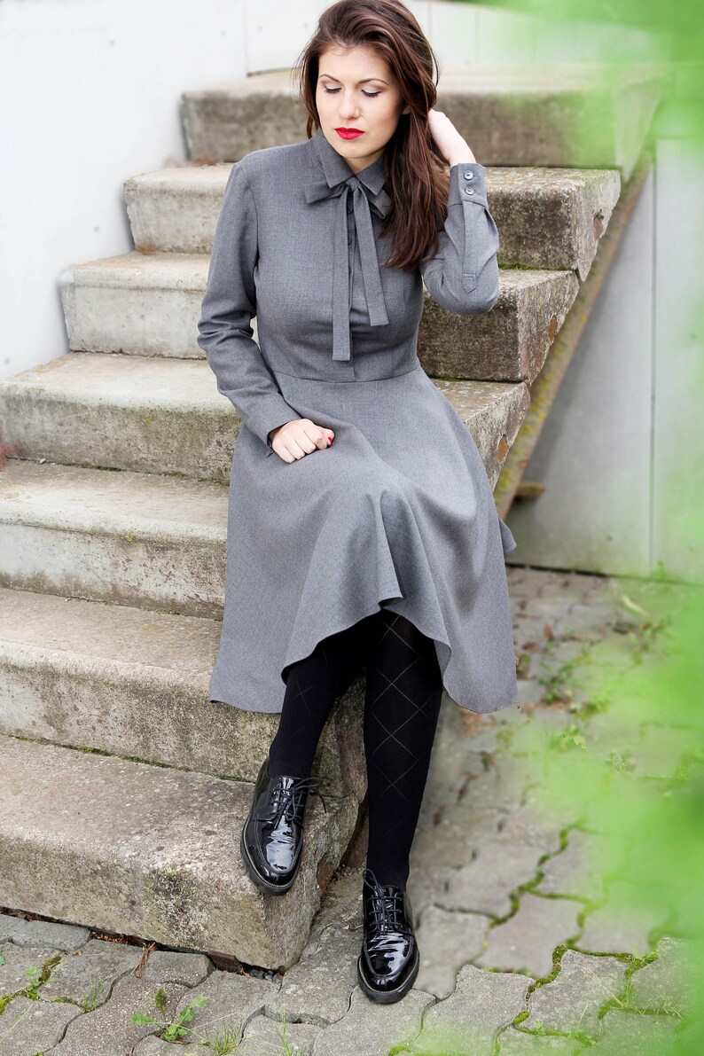 Elegant wool button up shirt dress with long sleeves. This midi dress is fitted at the top and has a flare skirt with side seam pockets.