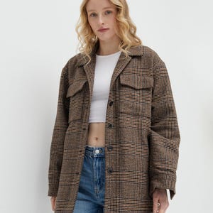 Brown, dark brown and beige checkered fall winter warm shirt jacket with warm lining, long sleeves and pockets.