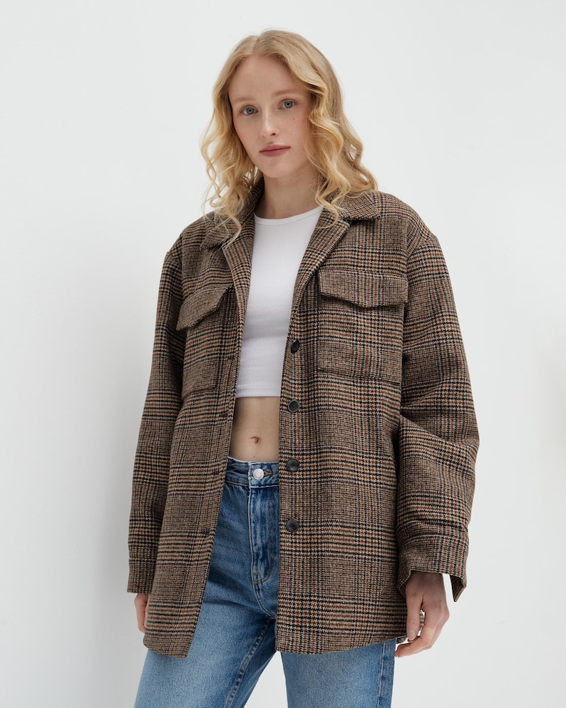 Brown, dark brown and beige checkered fall winter warm shirt jacket with warm lining, long sleeves and pockets.