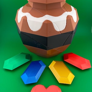 Puede incluir: Un jarrón geométrico marrón, blanco y negro con una base ancha y un cuello estrecho. Alrededor del jarrón hay cinco gemas facetadas de colores en verde, azul, amarillo y rojo, junto con una forma de corazón rojo. Los objetos están sobre un fondo verde.