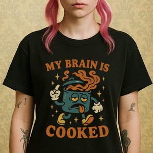 May include: Black t-shirt with a graphic of a cartoon pot with a face and the text "My brain is cooked".