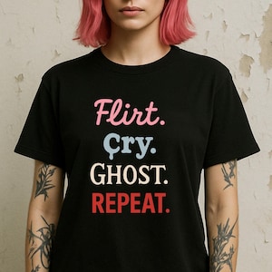 以下が含まれることがあります： ピンク、水色、白、赤で「Flirt. Cry. Ghost. Repeat.」と書かれた黒いTシャツ。Tシャツはクルーネックで半袖です。