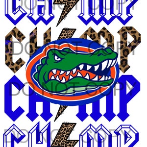 May include: A blue and white graphic with the word "Champ" in a bold, gothic font. The graphic features a lightning bolt with a leopard print pattern and a stylized alligator head in the center.