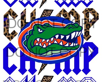 May include: A blue and white graphic with the word "Champ" in a bold, gothic font. The graphic features a lightning bolt with a leopard print pattern and a stylized alligator head in the center.