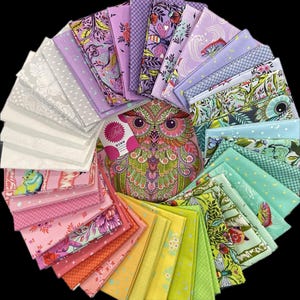 May include: A collection of fabric squares in various colors and patterns, arranged in a circular display. The fabrics include floral, geometric, and whimsical designs in shades of pink, purple, green, and yellow. A decorative owl-themed package is in the center.