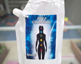 May include: A clear plastic pouch with a white screw cap containing liquid. The label features a blue background with a black silhouette of a human figure displaying seven colored chakra symbols, with the text AURA CLEANSING and Mystical Bath.