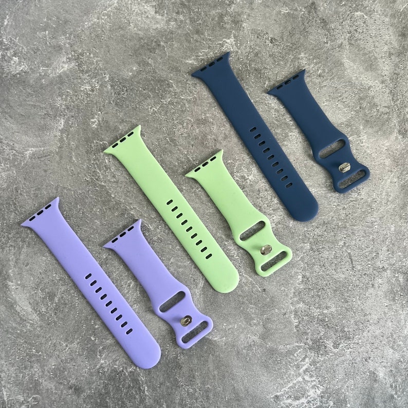 May include: Five different colored watch bands, including lavender, light green, and dark blue. The bands are made of a soft, flexible material and are designed to fit most standard watch sizes.