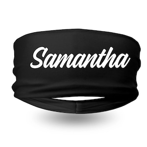 Puede incluir: Diadema negra con el nombre "Samantha" en blanco. La diadema es una banda ancha de tela sin costuras, probablemente para deportes o moda.