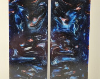 May include: Two rectangular pieces of blue, black, and pink marbled resin. The resin has a swirling pattern and a glossy finish.