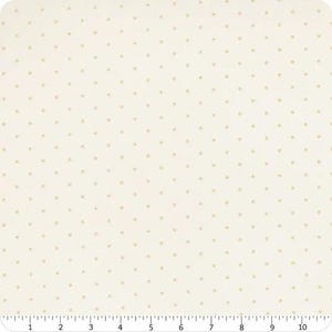 May include: A piece of off-white fabric featuring a repeating pattern of small, light tan polka dots. A ruler is visible along the bottom edge, showing a measurement scale from 0 to 10 inches, indicating the width of the textile material.