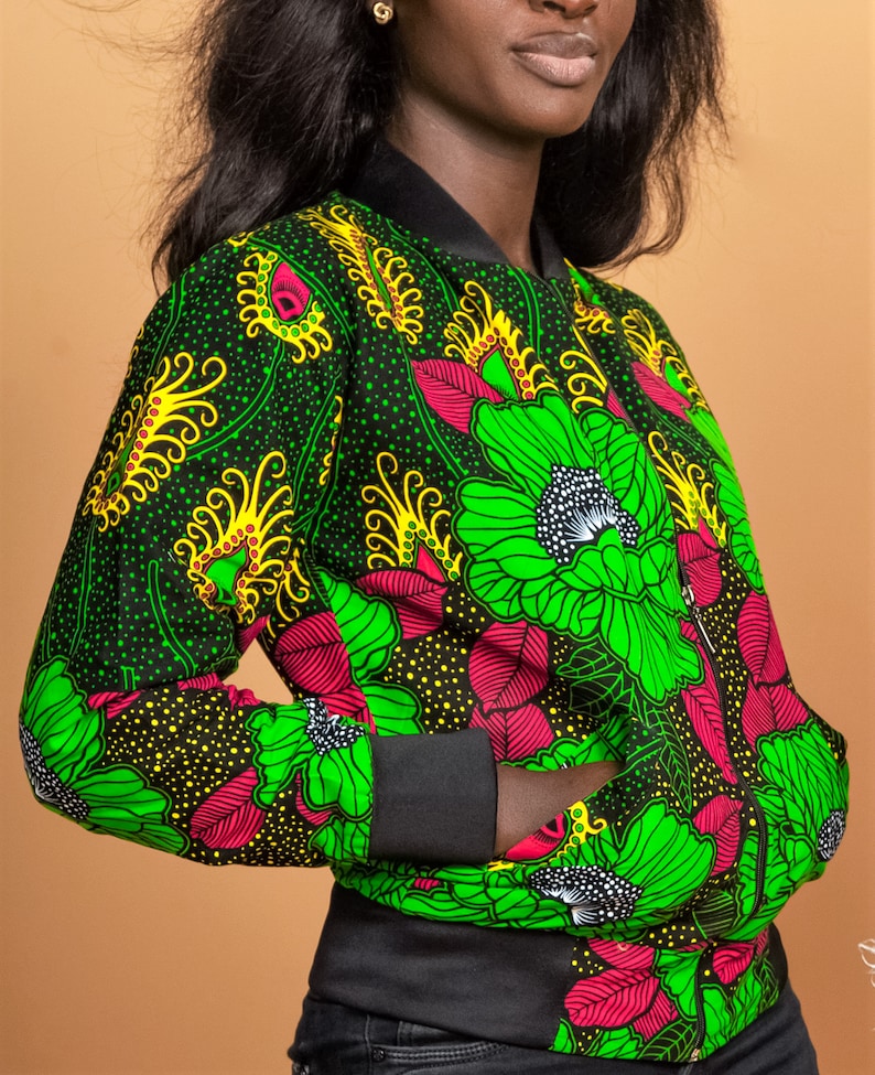 Puede incluir: Una chaqueta bomber negra con estampado floral verde, amarillo y rosa. La chaqueta tiene cierre de cremallera y cuello, pu&ntilde;os y cintura de canal&eacute;.