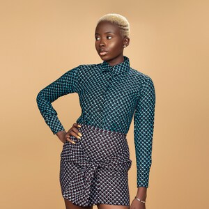 K&ouml;nnte beinhalten: Eine Person tr&auml;gt ein blau-schwarz gemustertes Hemd und einen schwarz-wei&szlig; gemusterten Rock. Die Person hat kurze blonde Haare.