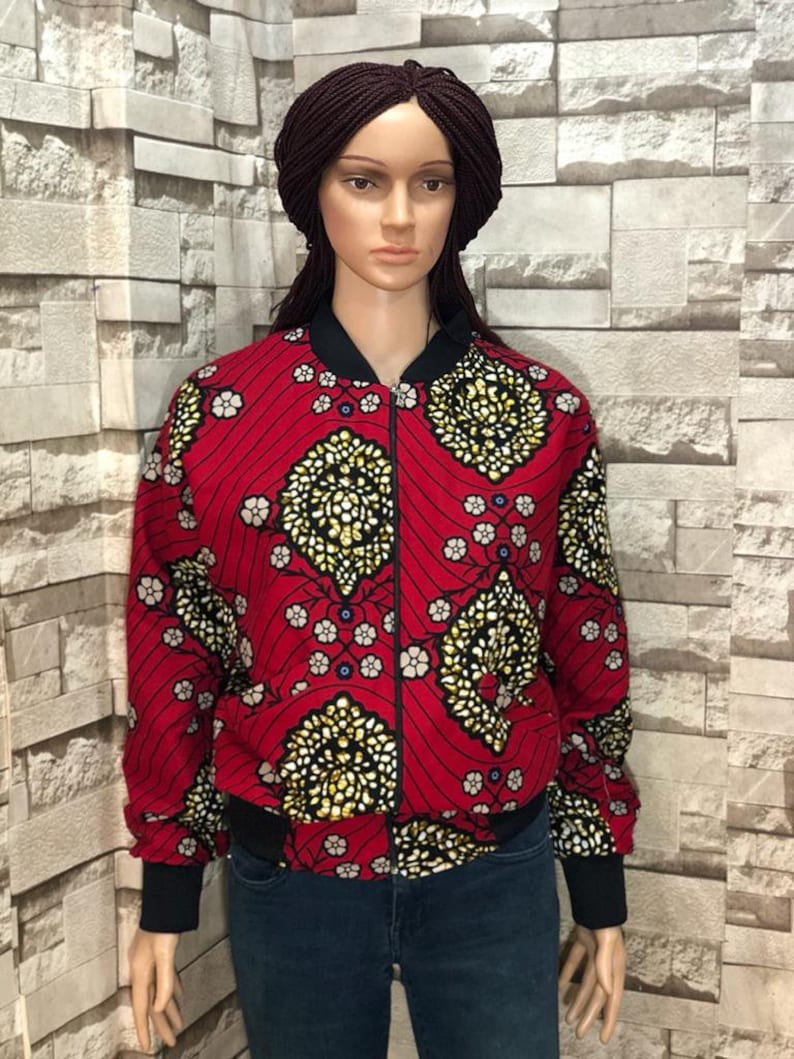 Puede incluir: Una chaqueta bomber roja con estampado floral negro y dorado. La chaqueta tiene cierre de cremallera y pu&ntilde;os y cintura de canal&eacute;.