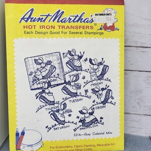 May include: A yellow and blue package of iron-on transfers featuring a design of mice dressed in clothing with the days of the week written on them. The package is labeled "Aunt Martha's Hot Iron Transfers" and "3216-Gay Colonial Miss".