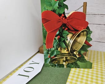 Tarjeta navideña con campanas y mensaje en el interior. Recibirás una tarjeta y un sobre. Ver descripción y fotos.