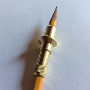 Peut inclure: Un porte-mine en laiton doré avec une bague en laiton et un crayon jaune inséré.