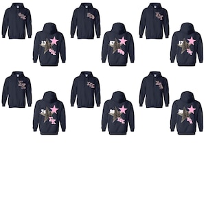 May include: Navy blue hooded sweatshirts with various designs. Some sweatshirts feature a pink star with a leopard print design and numbers, while others have text on the chest. The sweatshirts are a casual style.