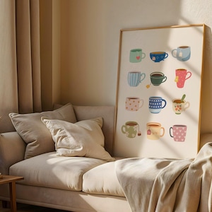 May include: A framed print displaying twelve illustrated teacups and mugs in diverse colours and patterns. The artwork includes heart, polka dot, and striped designs, with some cups holding tea bags or spoons. The print is displayed on a beige wall.