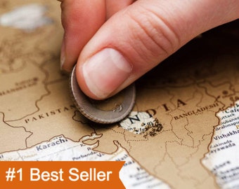 May include: A scratch-off world map featuring a tan surface with black printed country names and borders. A metallic coin is used to remove the top layer over the region of India, revealing a lighter colour underneath. The map includes the text #1 Best Seller.