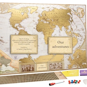 Peut inclure: Une grande carte du monde avec un rev&ecirc;tement en feuille d'or, sur fond blanc avec des continents d&eacute;taill&eacute;s. Elle comprend deux encadr&eacute;s rectangulaires avec du texte, un tube de rangement cylindrique, une grille d'autocollants dor&eacute;s, des punaises et un marqueur.