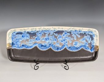 May include: A rectangular ceramic serving tray with a dark brown base and a white rim. The rim has a blue and white marbled design with a scalloped edge.