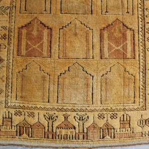 May include: A vintage prayer rug with a traditional design featuring arches and geometric patterns in shades of brown and beige.