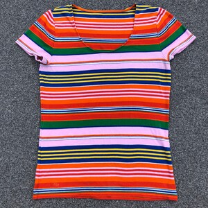 Peut inclure: Un t-shirt &agrave; manches courtes ray&eacute; avec un col rond. Le t-shirt a des rayures altern&eacute;es de rose, orange, rouge, vert, bleu et jaune. Le t-shirt a les lettres "RL" sur le c&ocirc;t&eacute; inf&eacute;rieur gauche.