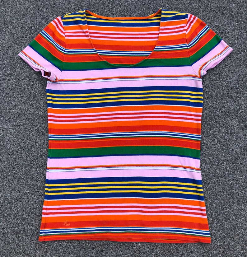 Peut inclure: Un t-shirt &agrave; manches courtes ray&eacute; avec un col rond. Le t-shirt a des rayures altern&eacute;es de rose, orange, rouge, vert, bleu et jaune. Le t-shirt a les lettres "RL" sur le c&ocirc;t&eacute; inf&eacute;rieur gauche.