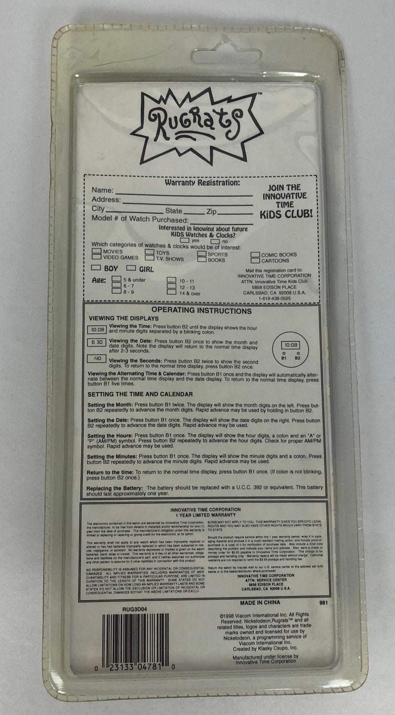 May include: Rugrats Kids Club watch with a white face and black numbers. The watch has a black band and a white plastic case. The back of the packaging includes instructions for setting the time and date, as well as warranty information.