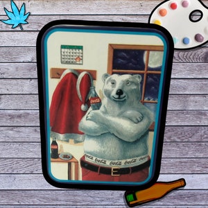May include: A white polar bear wearing a red Santa hat and a belt with the words "Coca-Cola" repeated on it. The bear is holding a bottle of Coca-Cola in its right paw and is standing in front of a window with a night sky and a full moon. There is a calendar on the wall behind the bear.