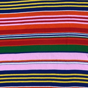 Peut inclure: Un tissu ray&eacute; avec des bandes altern&eacute;es de rose, rouge, orange, jaune, vert, bleu et blanc.