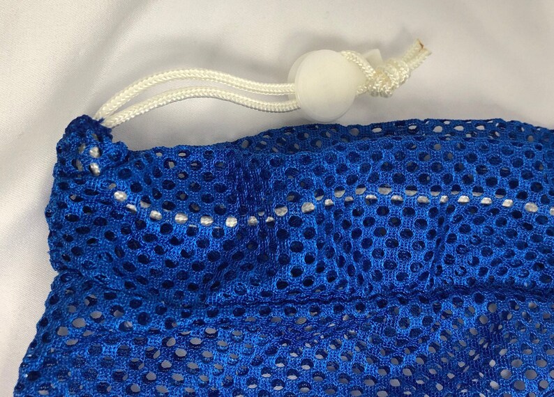 May include: A blue mesh laundry bag with a white drawstring and a white toggle.