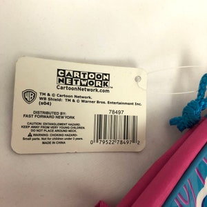 May include: A pink and blue drawstring bag with a Cartoon Network logo and the text "Cartoon Network.com". The bag has a white tag with a barcode and the text "Distributed by: Fast Forward New York".