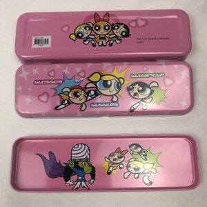 May include: Pink metal pencil case featuring the Powerpuff Girls characters: Blossom, Bubbles, and Buttercup. The case also includes the character Mojo Jojo. TM & &copy; Cartoon Network. (S01)