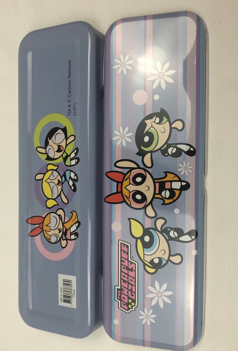 May include: A purple pencil case with a striped design and images of the Powerpuff Girls. The text "The Powerpuff Girls" is printed on the case. The back of the case has images of the Powerpuff Girls and the text "TM & Cartoon Network (s01)".