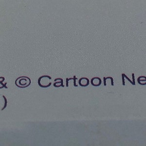 May include: A blue background with a yellow circle and a black and white cartoon character. The text "TM & &copy; Cartoon Network (s01)" is printed in purple.