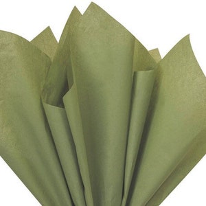 May include: Olive green tissue paper fanned out against a white background. The tissue paper is folded and layered, creating a textured, voluminous appearance. The color is a muted, earthy green.